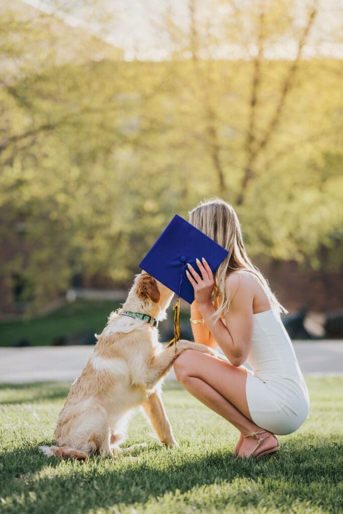 College graduate with dog during graduation session at Minnesota State University Mankato
